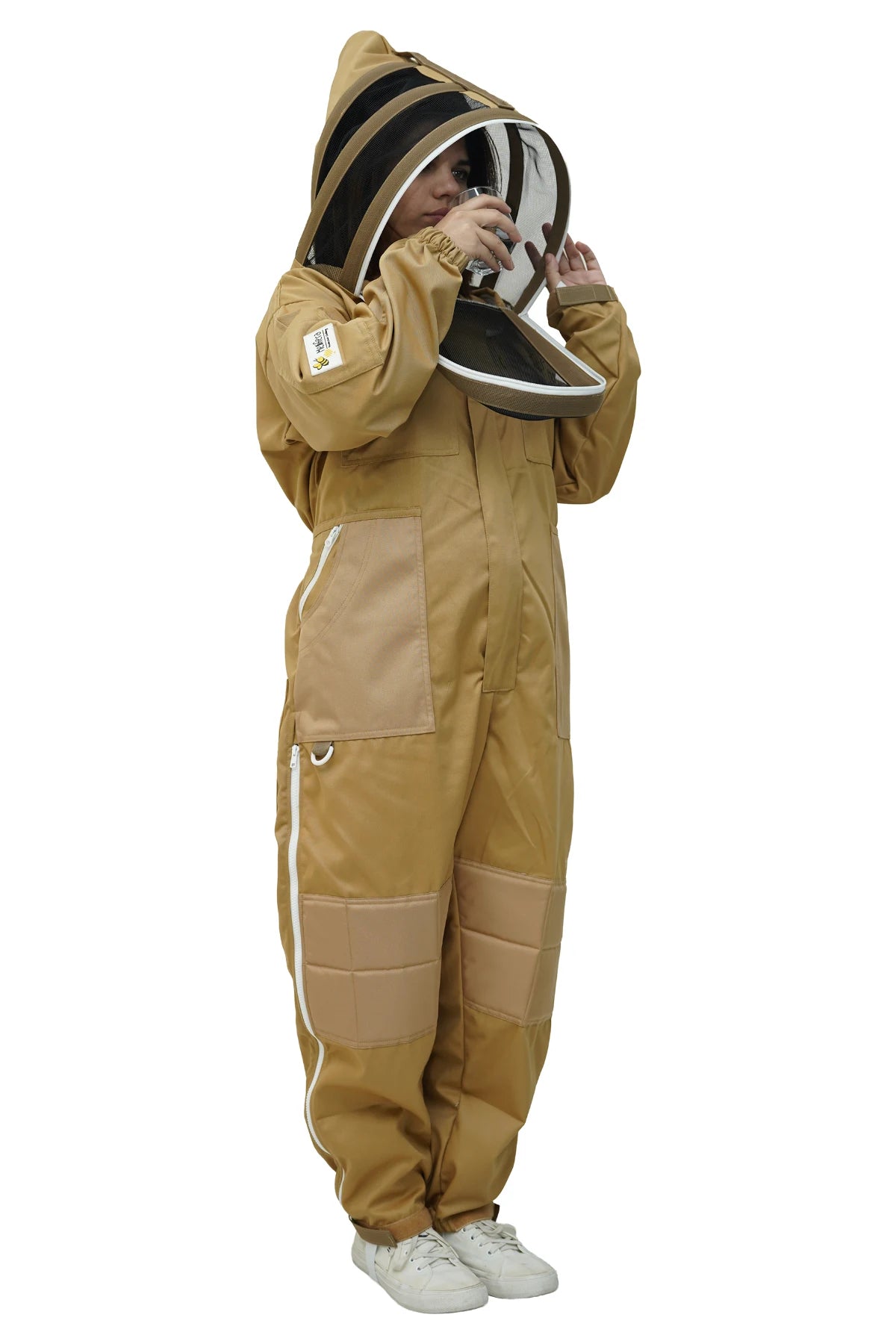 Beekeeper drinking water through the fencing veil of the khaki poly cotton beekeeping suit