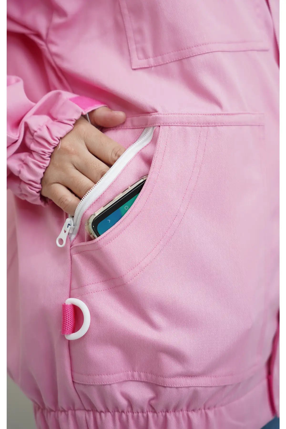 Close-up of the side zip pocket holding a smartphone on the pink poly cotton beekeeping jacket